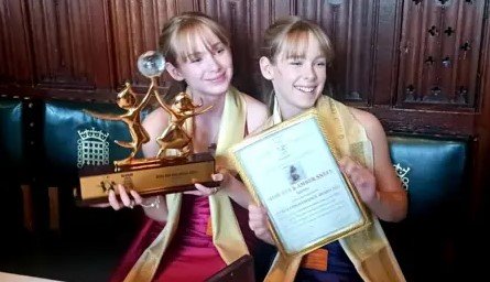 identical twin archers receiving award in Houses of Parliament