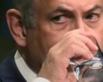 Benjamin Netanyahu holding glass of water