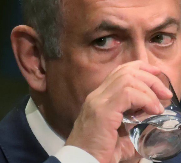 Benjamin Netanyahu holding glass of water