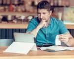 small business owner checking economic data on tablet shop