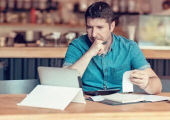 small business owner checking economic data on tablet shop