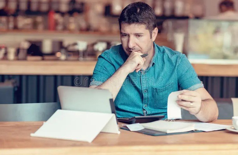 small business owner checking economic data on tablet shop