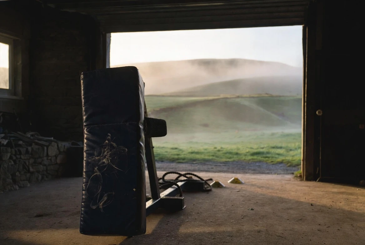 GSI Performance contact training sled inside a Galashiels workshop with Scottish Borders hills behind.